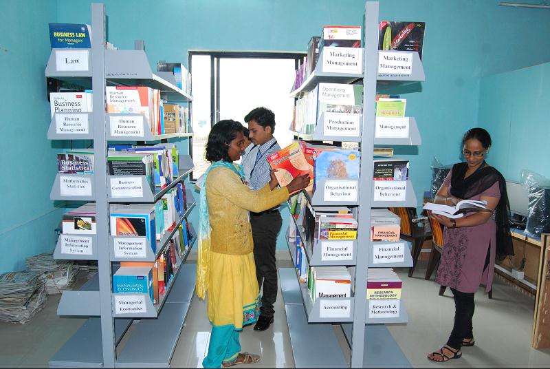 Students using the library bookshelves